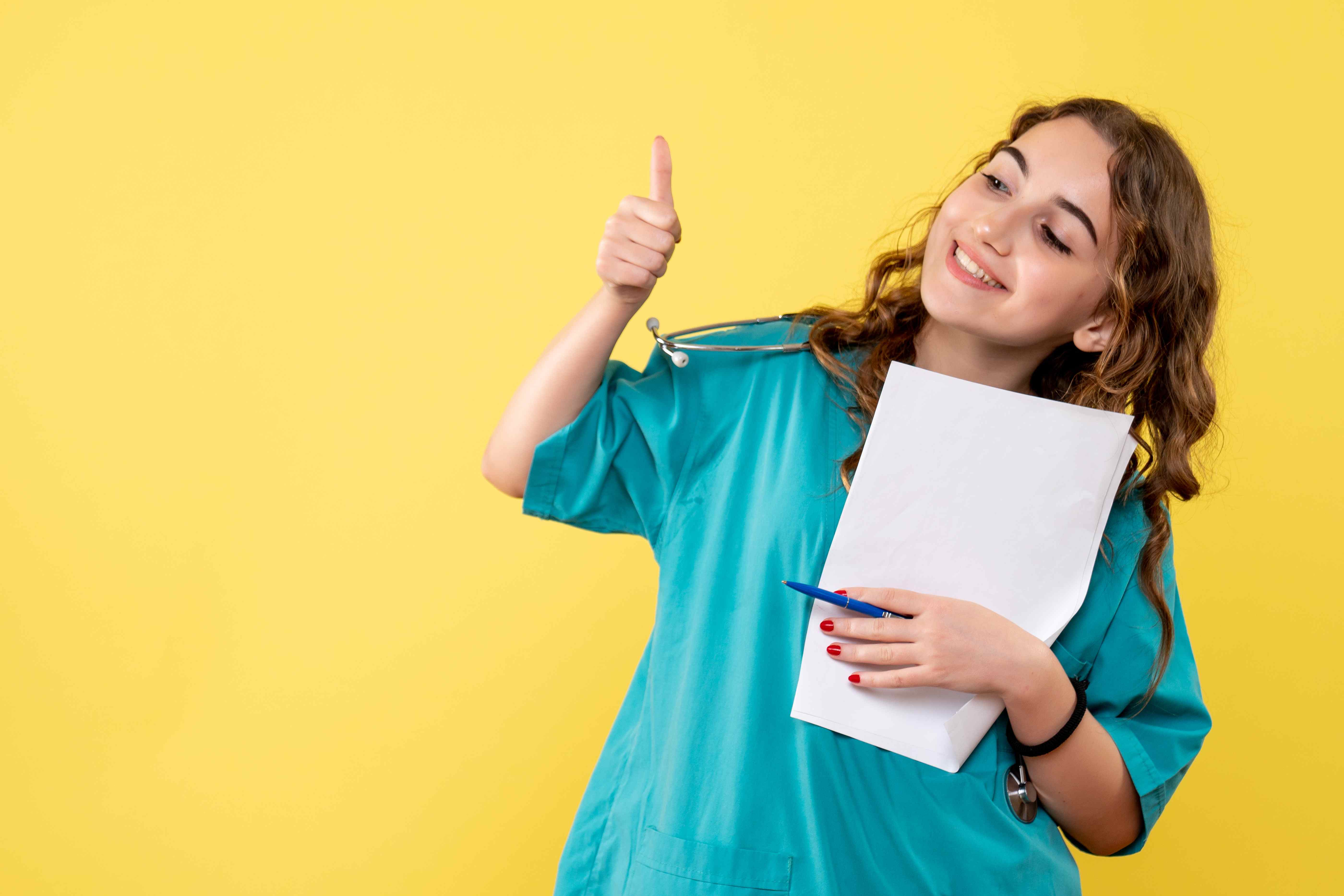 Jeune fille qui leve le pouce de satisfaction reussite examen