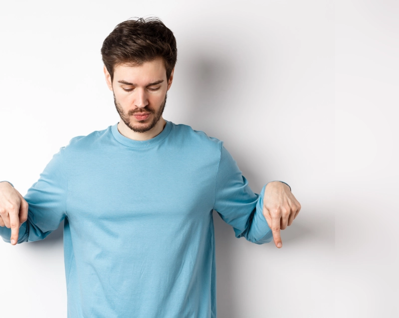 homme regardant vers le bas, ses index pointant vers le bas