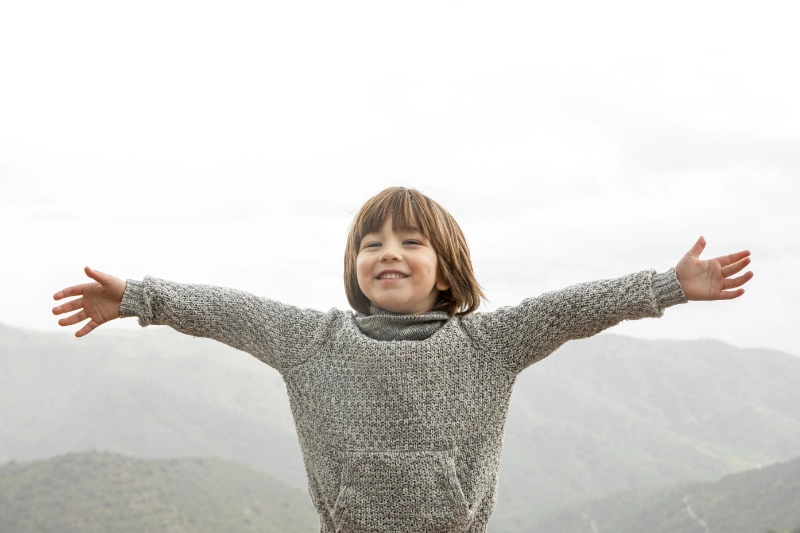 enfant en haut du montagne fier de l'avoir gravie