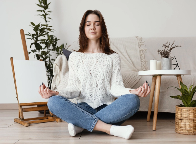 femme en tailleur les yeux fermés, en pleine méditation